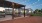 Picnic tables under a pergola with string lights